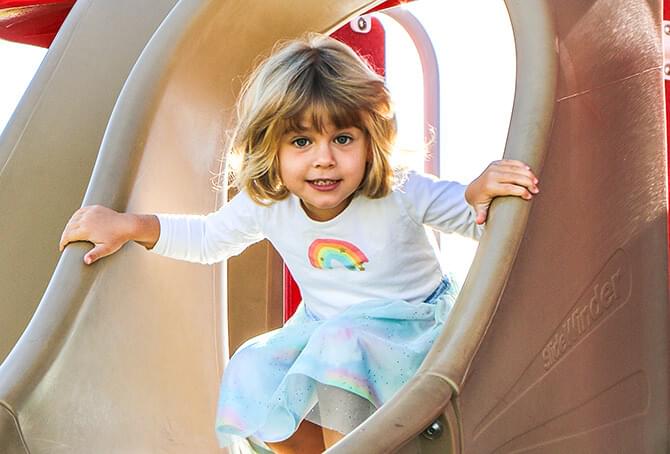 Girl about to go down a slide