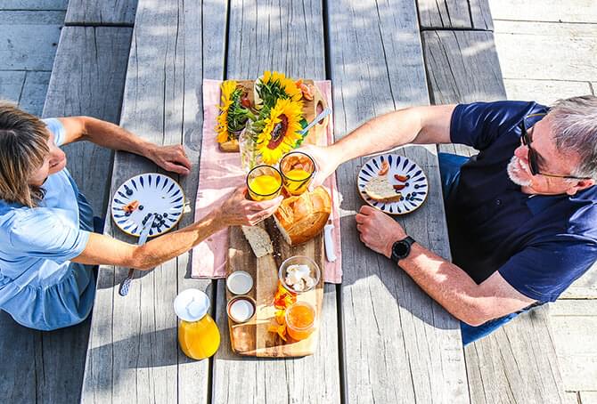 Two people sitting at a dining table toasting